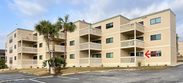 view of apartment building / complex featuring uncovered parking