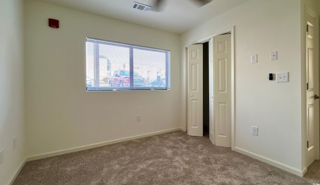 unfurnished bedroom with a closet, light colored carpet, and ceiling fan