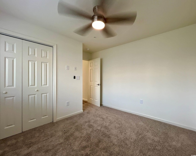 unfurnished bedroom with carpet, a closet, baseboards, and ceiling fan
