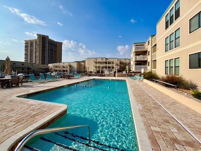 community pool with a patio and fence