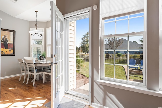 dining space featuring hardwood / wood-style flooring and a chandelier