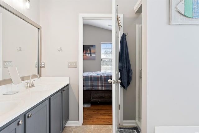 bathroom with vanity, vaulted ceiling, and tile patterned flooring