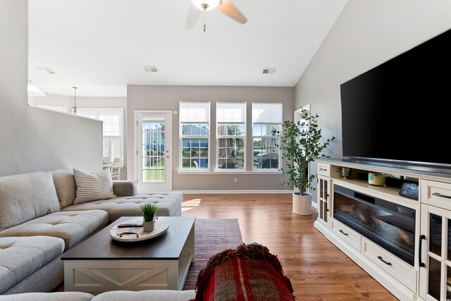 living room with hardwood / wood-style floors, vaulted ceiling, and ceiling fan