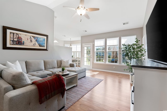 living room featuring light hardwood / wood-style floors, lofted ceiling, and ceiling fan