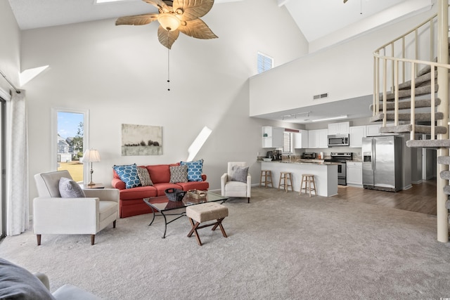 living room featuring carpet flooring, ceiling fan, and high vaulted ceiling