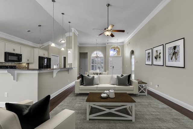 living room with dark wood-style flooring, arched walkways, baseboards, a ceiling fan, and crown molding