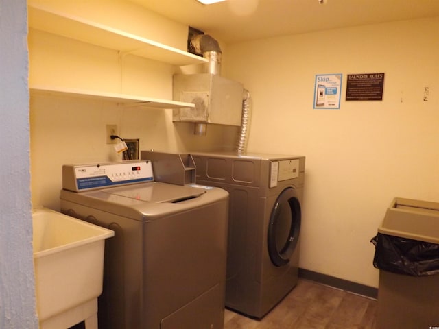 washroom with sink, hardwood / wood-style flooring, and washer and clothes dryer