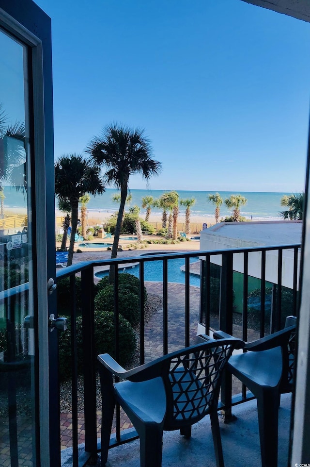 balcony featuring a water view and a beach view