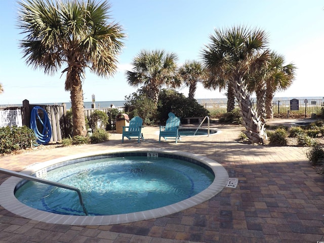 view of swimming pool with a hot tub and a patio area