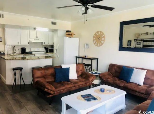 living room with dark hardwood / wood-style floors, sink, and ceiling fan