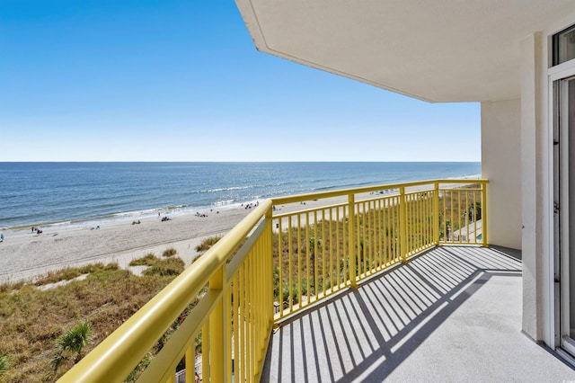 balcony featuring a view of the beach and a water view