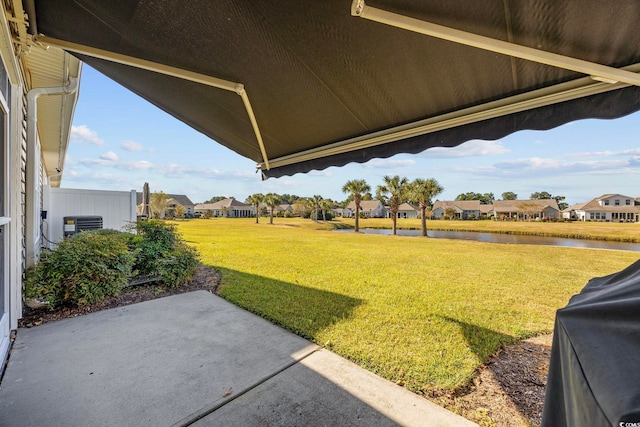 view of yard featuring a water view and a patio area