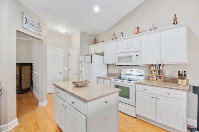 kitchen with white cabinetry, light wood-type flooring, vaulted ceiling, white appliances, and a center island