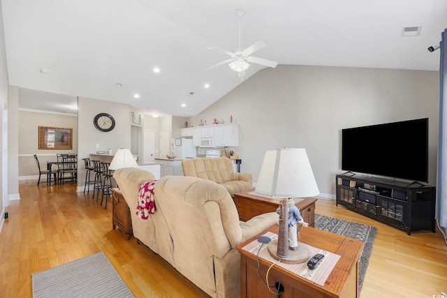 living room with light hardwood / wood-style floors, lofted ceiling, and ceiling fan