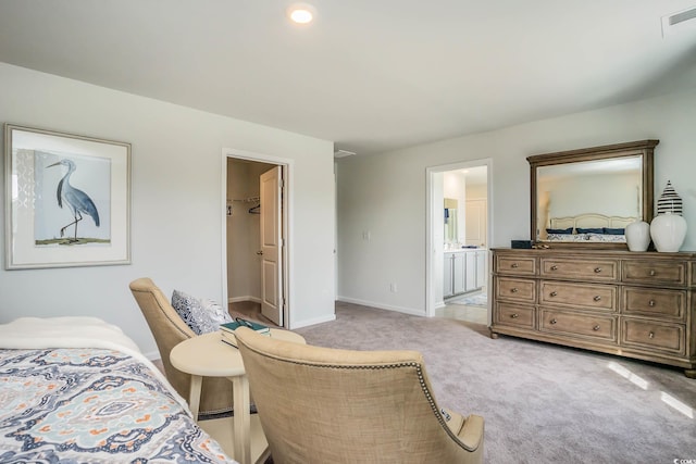 carpeted bedroom featuring a walk in closet, ensuite bath, and a closet