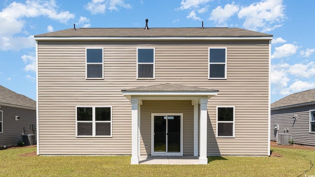 back of property with a yard, a patio, and central AC