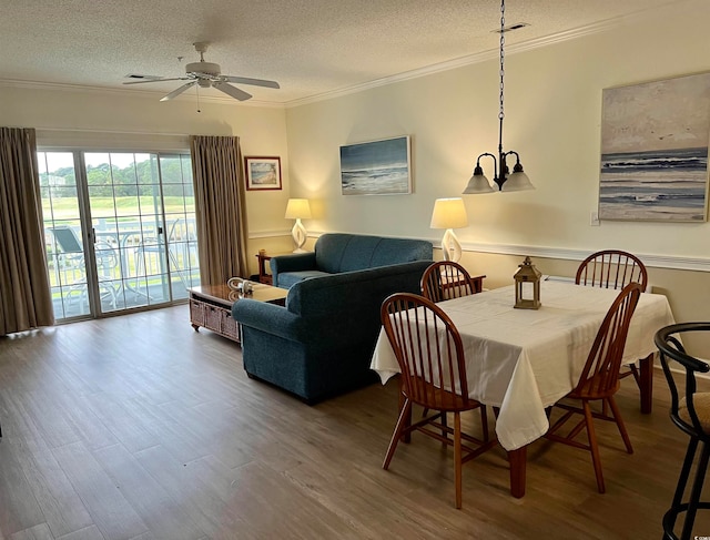 dining room featuring wood-type flooring, a textured ceiling, and ornamental molding