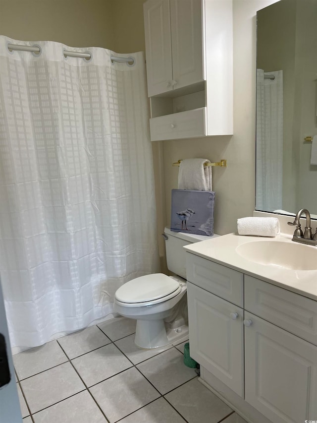 bathroom with tile patterned flooring, vanity, and toilet