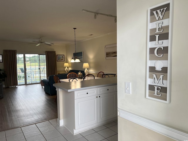 kitchen with light wood-type flooring, rail lighting, ceiling fan, pendant lighting, and white cabinets