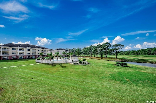 view of home's community with a lawn and a water view