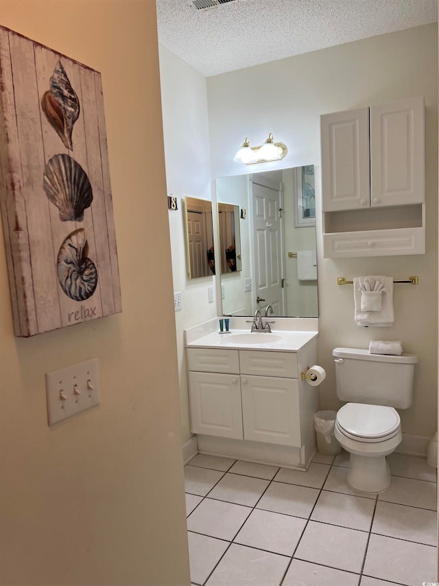 bathroom featuring vanity, a textured ceiling, tile patterned floors, and toilet