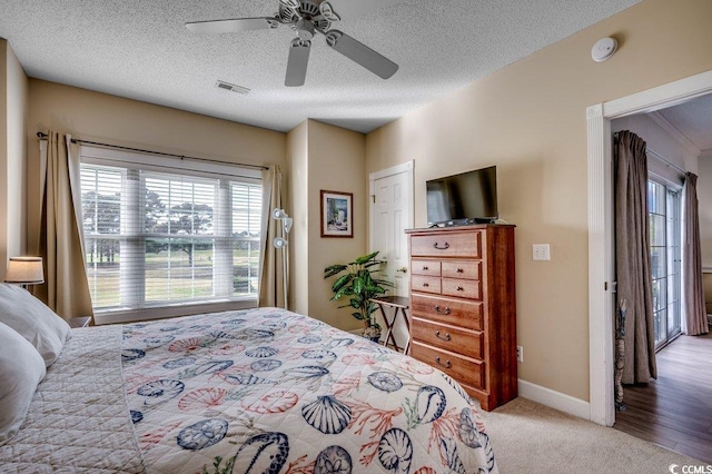 bedroom featuring a textured ceiling, light wood-type flooring, and ceiling fan