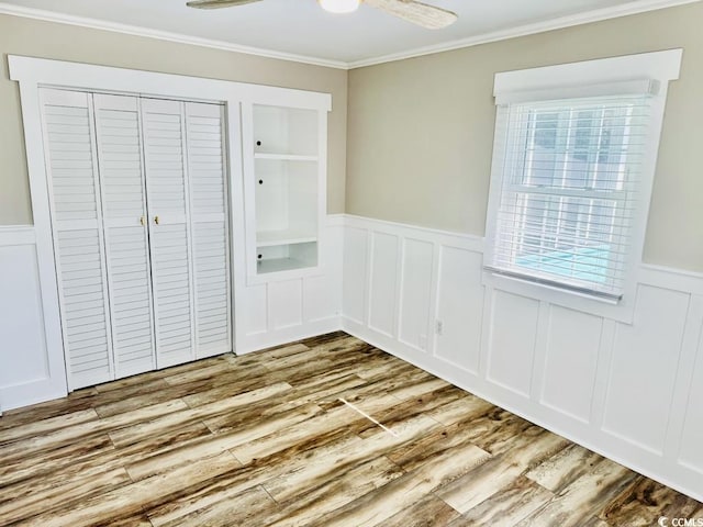 3936 Murrells Inlet Rd, Murrells Inlet, SC 29576 - unfurnished bedroom featuring a wainscoted wall, ornamental molding, wood finished floors, a decorative wall, and a closet