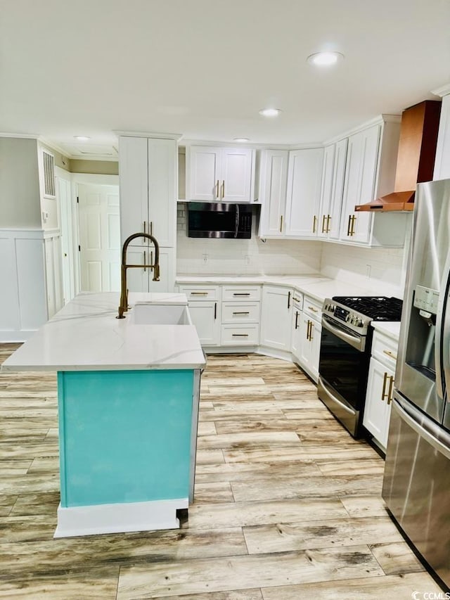 3936 Murrells Inlet Rd, Murrells Inlet, SC 29576 - kitchen featuring appliances with stainless steel finishes, white cabinetry, light wood-style flooring, a kitchen island with sink, and recessed lighting