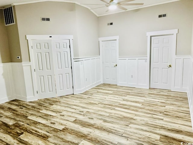 3936 Murrells Inlet Rd, Murrells Inlet, SC 29576 - unfurnished bedroom with light wood-style flooring, crown molding, a wainscoted wall, a decorative wall, and high vaulted ceiling