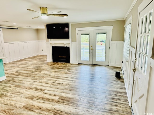 3936 Murrells Inlet Rd, Murrells Inlet, SC 29576 - unfurnished living room featuring french doors, crown molding, ceiling fan, a barn door, and a decorative wall