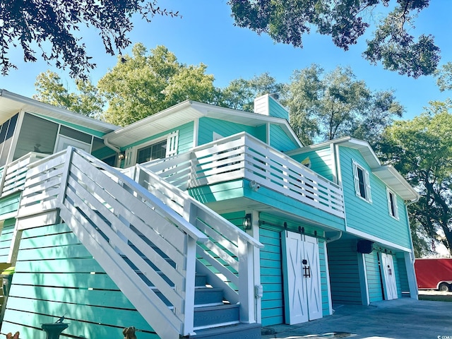3936 Murrells Inlet Rd, Murrells Inlet, SC 29576 - view of home's exterior with a chimney, stairs, an attached garage, and driveway