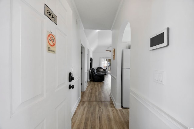 hallway with light wood-type flooring and ornamental molding