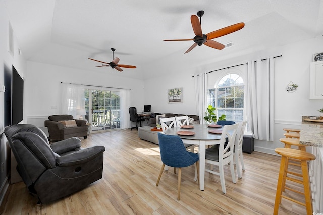 dining space with visible vents, a healthy amount of sunlight, light wood-style flooring, and a ceiling fan