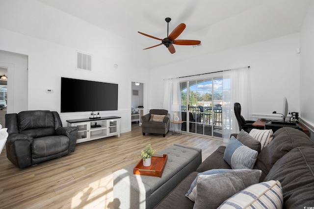 living room featuring high vaulted ceiling, light wood-type flooring, visible vents, and ceiling fan