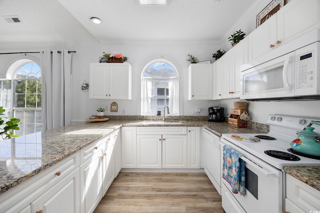 kitchen with a sink, visible vents, white appliances, and a healthy amount of sunlight