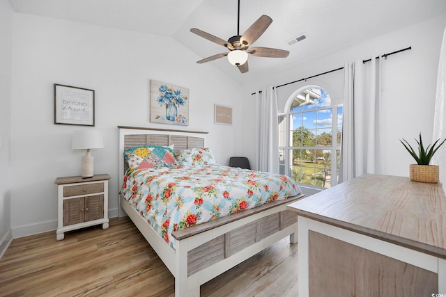 bedroom featuring light wood-type flooring, visible vents, lofted ceiling, a ceiling fan, and baseboards