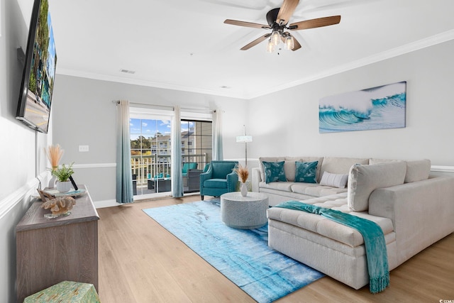 living room featuring crown molding, light wood-type flooring, and ceiling fan