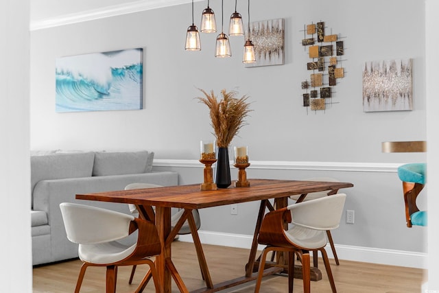 dining area with hardwood / wood-style flooring and ornamental molding