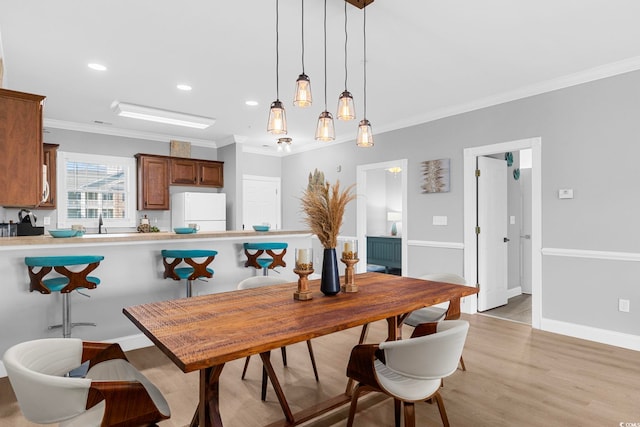 dining room featuring crown molding and light hardwood / wood-style flooring