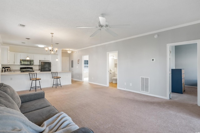 living room with ceiling fan with notable chandelier, ornamental molding, a textured ceiling, and light colored carpet