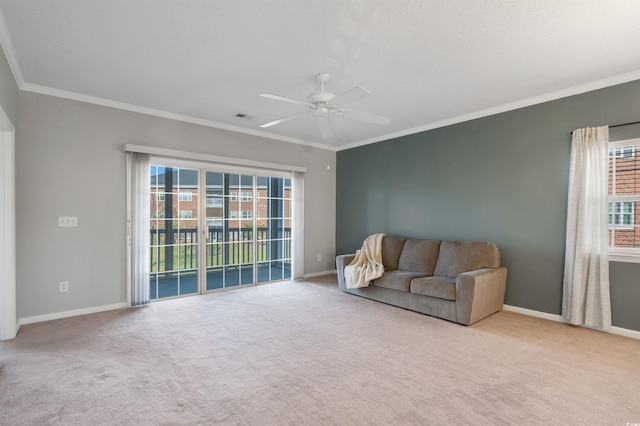 carpeted living room with crown molding and ceiling fan