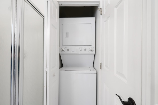 clothes washing area with stacked washer / dryer