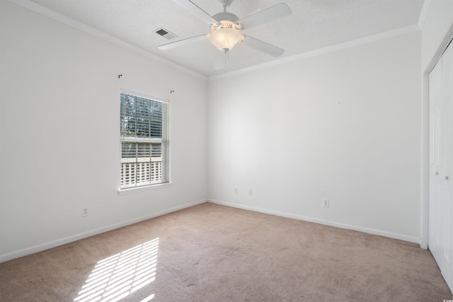 carpeted empty room with crown molding, a textured ceiling, and ceiling fan