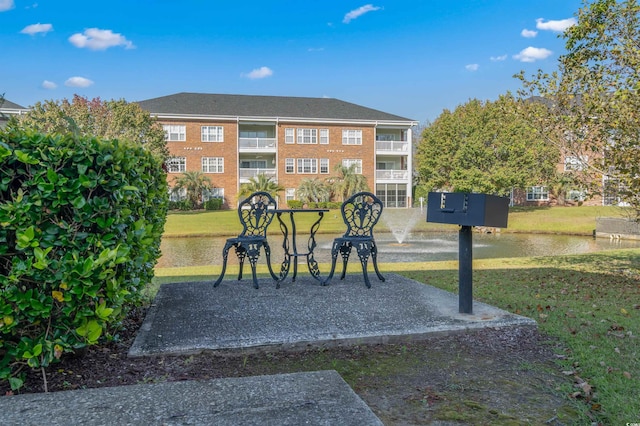 view of property's community featuring a water view and a lawn