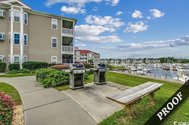 view of home's community with a lawn and a water view