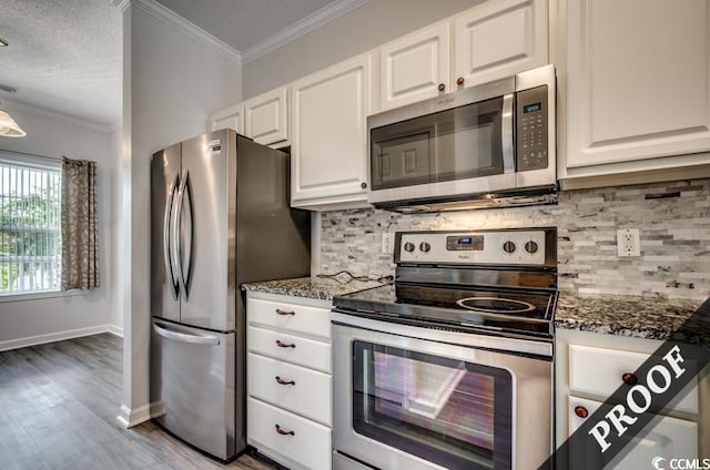 4220 Coquina Harbour Dr Unit B-11, Little River, SC 29566 - kitchen with appliances with stainless steel finishes, crown molding, white cabinets, dark stone countertops, and backsplash