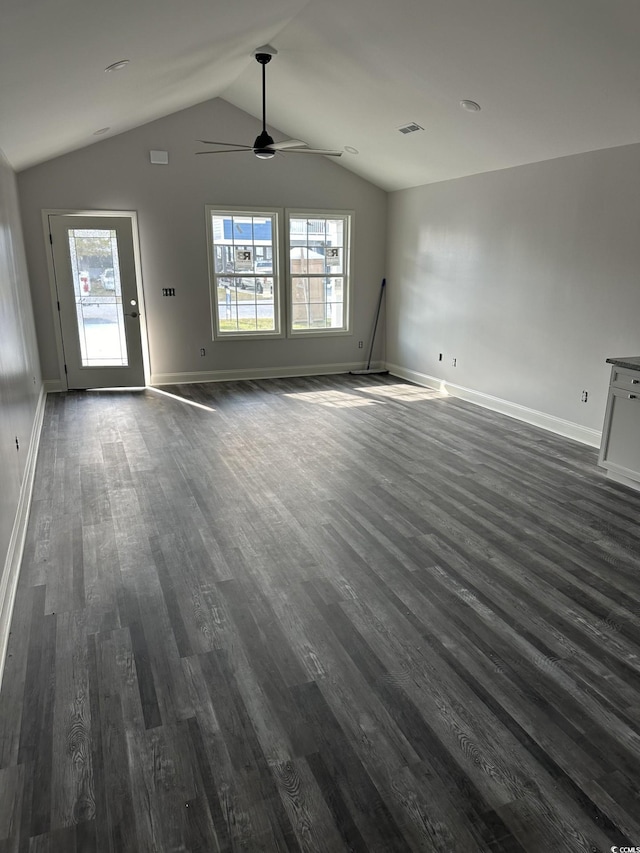 unfurnished living room featuring lofted ceiling, dark hardwood / wood-style floors, ceiling fan, and a healthy amount of sunlight