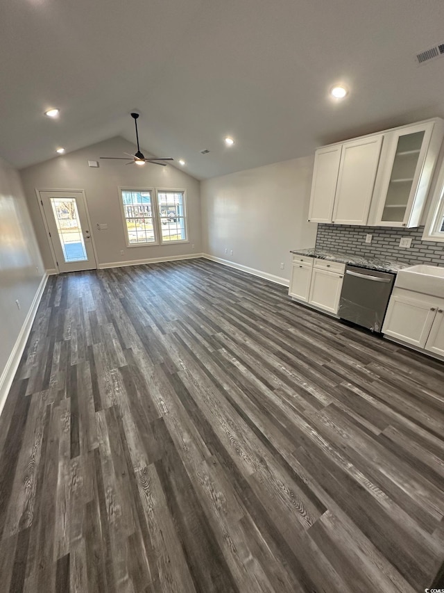 kitchen featuring dishwasher, backsplash, vaulted ceiling, dark hardwood / wood-style flooring, and white cabinetry