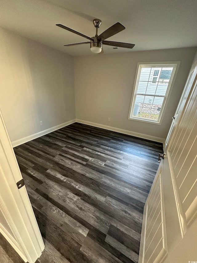 unfurnished room with ceiling fan and dark wood-type flooring