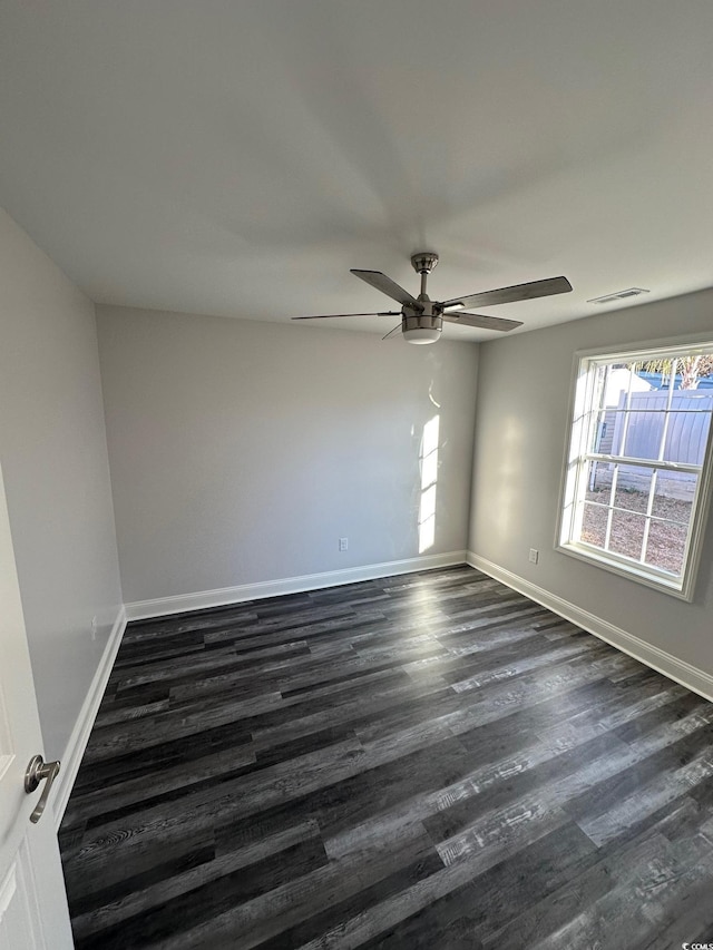 empty room with ceiling fan and dark hardwood / wood-style floors